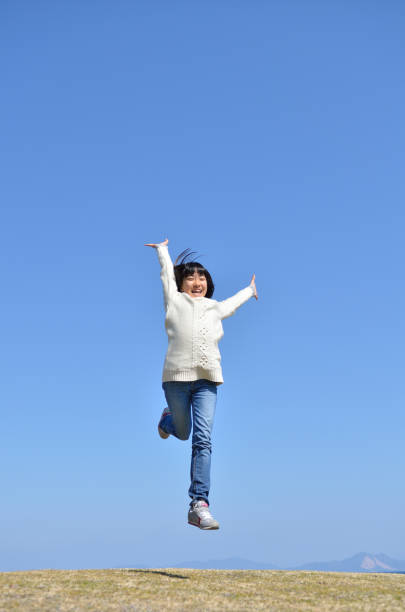 istock Girl's jumping in the blue sky 923639058