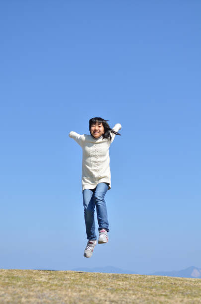 istock Girl's jumping in the blue sky 923639062