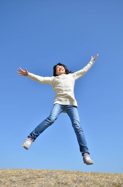 istock Girl's jumping in the blue sky 923639206