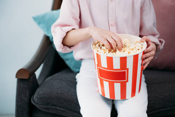 istock cropped shot of kid with popcorn sitting on sofa at home 923645748