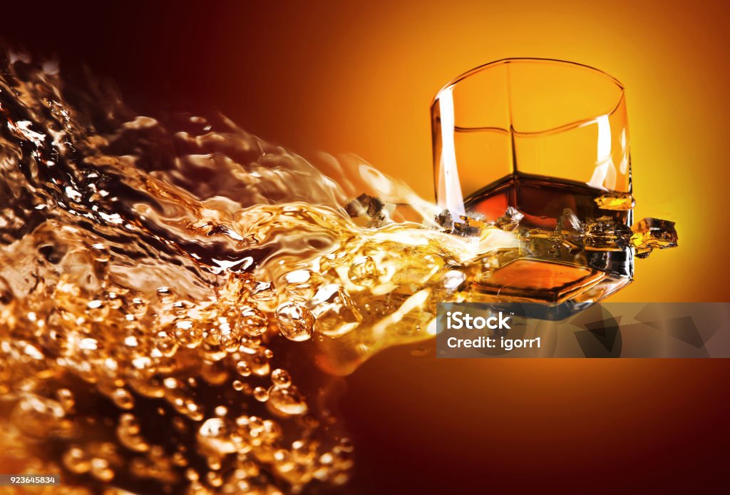 Glass of whiskey with ice. View from the bottom . Glass of whiskey with ice. View from the bottom . Conceptual image with abstract splashing . Copy space . Liquid Stock Photo