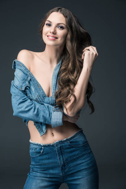 istock smiling seductive woman posing in denim shirt, isolated on grey 923645954