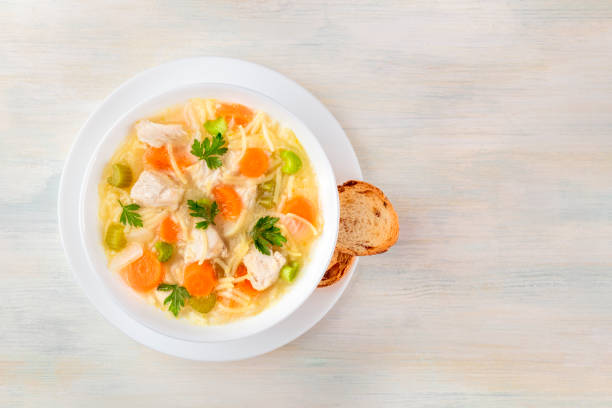 hühnersuppe mit nudeln, obenliegende foto mit exemplar - hühnersuppe stock-fotos und bilder