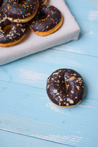 istock Chocolate glazed donuts on wooden background with blank space 923649844