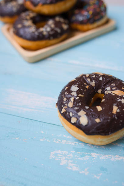 istock Chocolate glazed donuts on wooden background with blank space 923652262