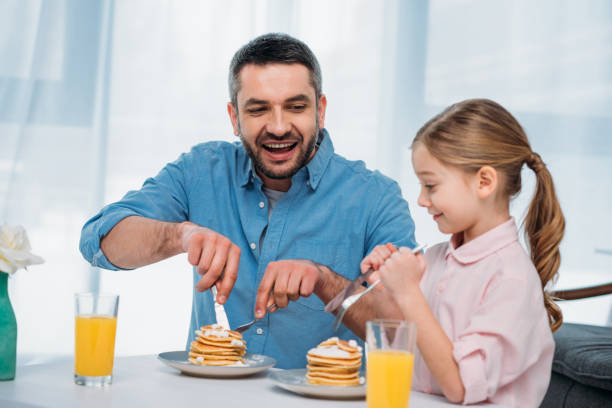 istock cheerful father and little daughter having breakfast at home 923652308