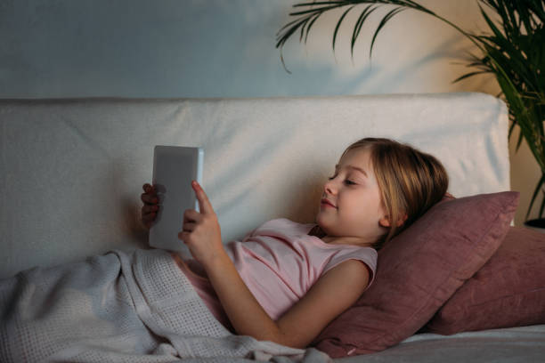 istock side view of little kid using tablet in bed at home 923652716