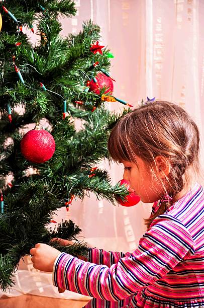 女の子はクリスマスツリーの装飾 ストックフォト