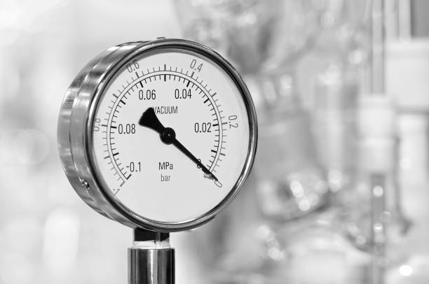 Pressure gauge on a blurry industrial background. Toned image.