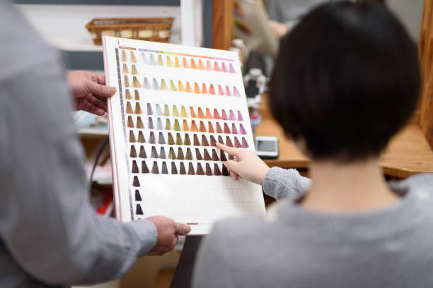 Female customer choosing hair color in hair salon Female customer choosing favorite color from color chart in hair salon flaxen hair color stock pictures, royalty-free photos & images