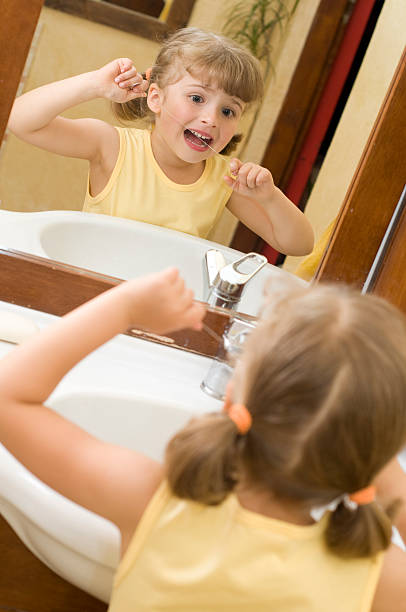 istock Cute girl cleaning teeth by floss 92365862