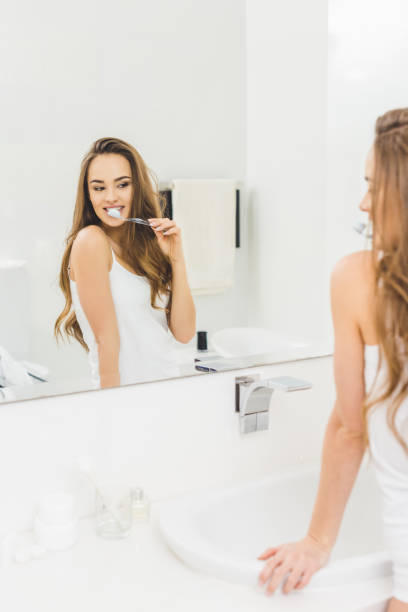 istock young woman brushing teeth in morning at home 923666734