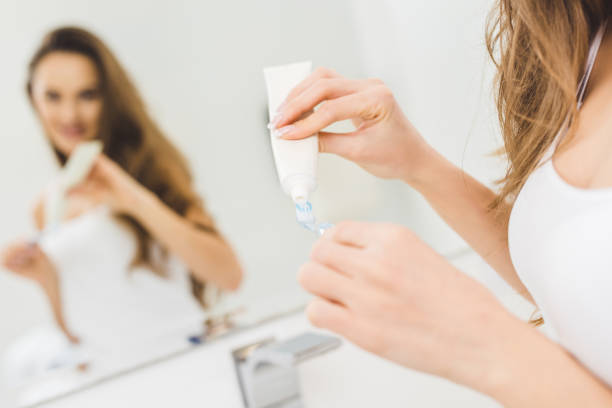 istock partial view of woman applying toothpaste on toothbrush in hands 923666794