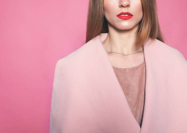 長いブロンドの髪とピンクの背景のピンクのコートに赤の開いた唇ファッション若い深刻な女性。クローズ アップ。コピー スペース。スタジオ撮影 - studio shot mouth open horizontal head and shoulders ストックフォトと画像