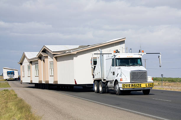 a semi truck transporting a house along a road