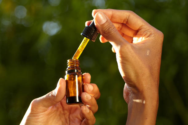 a dropper containing CBD oil a dropper containing CBD oil in a woman's hand cbd oil photos stock pictures, royalty-free photos & images