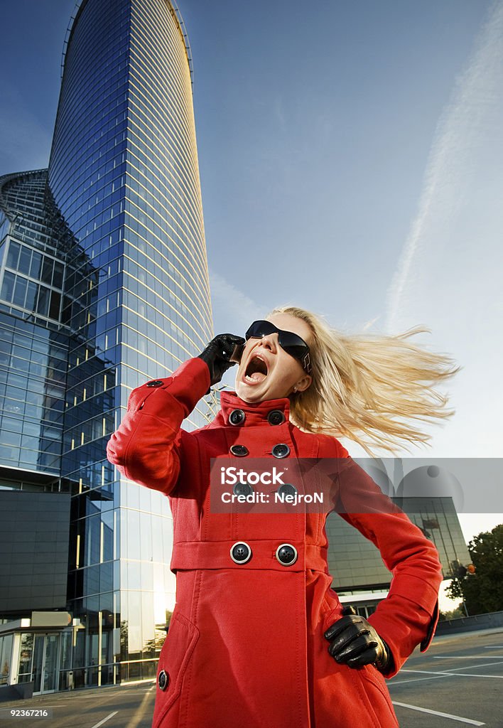 Злая молодая женщина с мобильного телефона - Стоковые фото Ветер роялти-фри