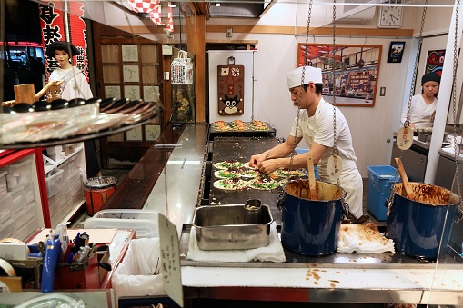 Kyoto: Restaurant chef prepares Japanese style okonomiyaki pancakes in Kyoto, Japan.