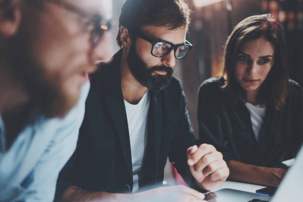 istock Concept of teamwork process at office.Young team working together at night modern office loft.Blurred background.Horizontal. 923674982