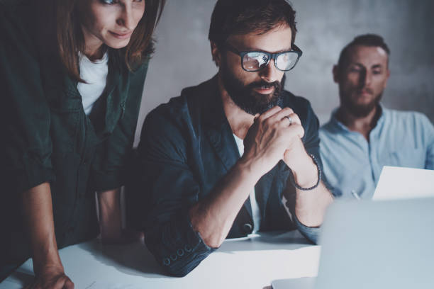 istock Coworkers working together in modern office with paper documents and laptops.Horizontal.Blurred background.Cropped. 923675028