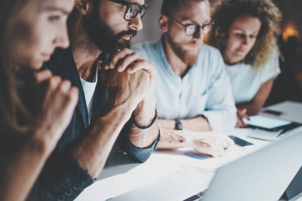istock Group of young entrepreneurs are looking for a business solution during work process at night office.Business people meeting concept.Blurred background.Horizontal. 923677722