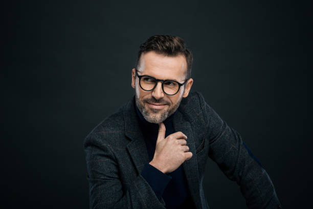 istock Studio portrait of smiling elegant man, dark background 923678654