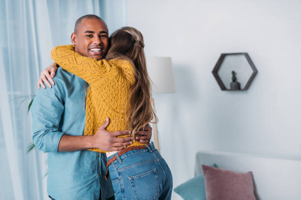 istock smiling multicultural couple hugging in room 923681928