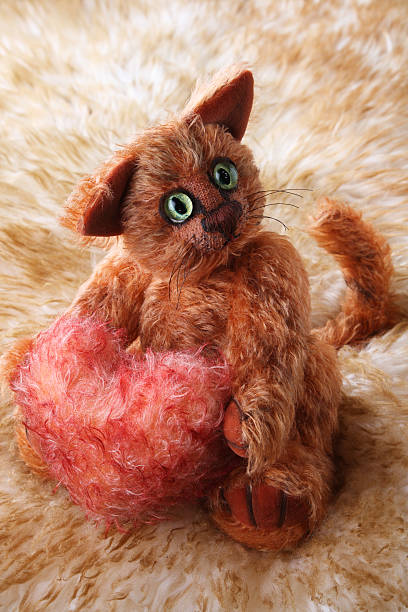 istock Cat holding fluffy heart in his paws on fur background 92368223