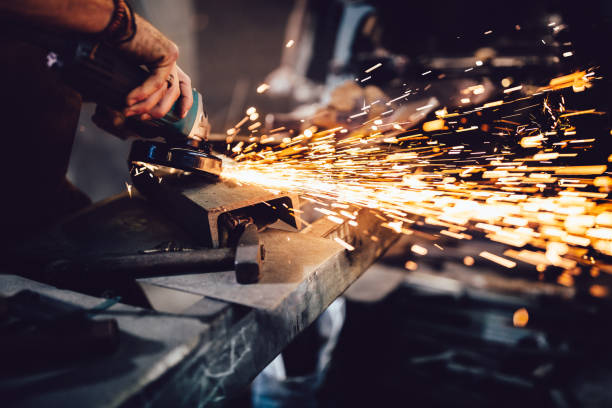 trabalhar com ferramentas elétricas e metais na oficina de ferreiro - grinding - fotografias e filmes do acervo