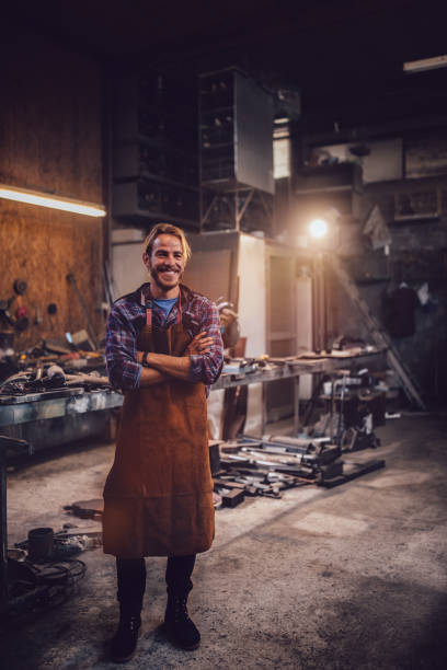 istock Portrait of happy professional blacksmith standing in workshop 923686544