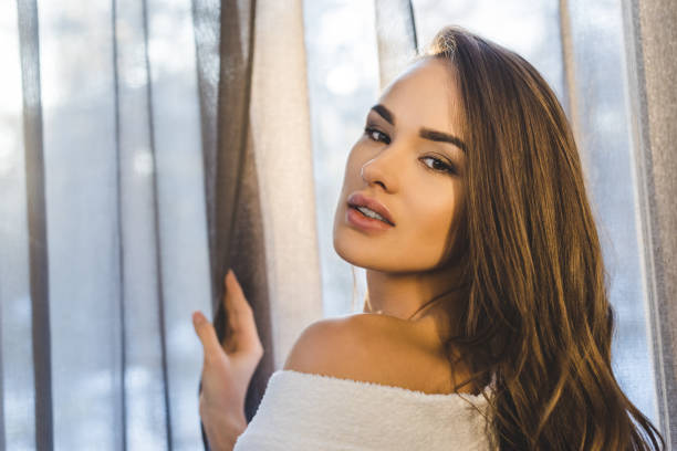 istock attractive young woman in bathrobe looking at camera at home 923693496