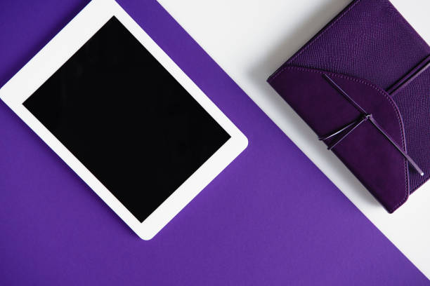 istock top view of tablet and notebook on white and purple surface 923702424