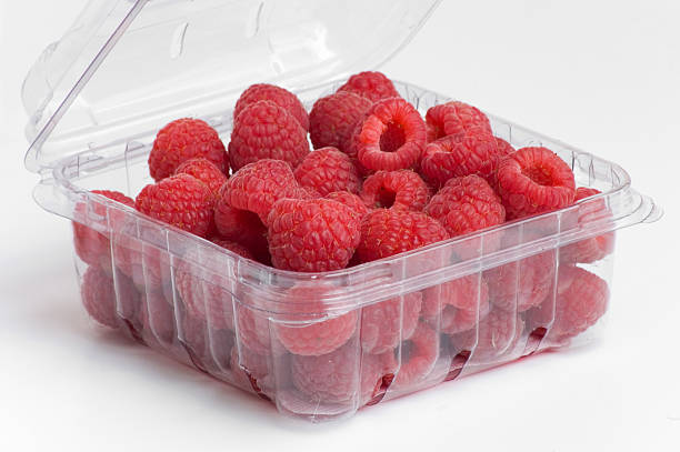 red raspberries in plastic container stock photo