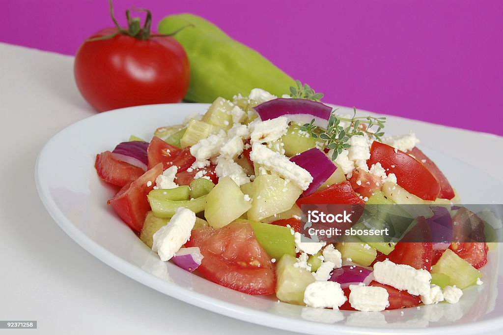 Greek salad Colorful fresh Greek salad of tomato, cucumber, pepper, and feta cheese, garnished with fresh herbs. Appetizer Stock Photo