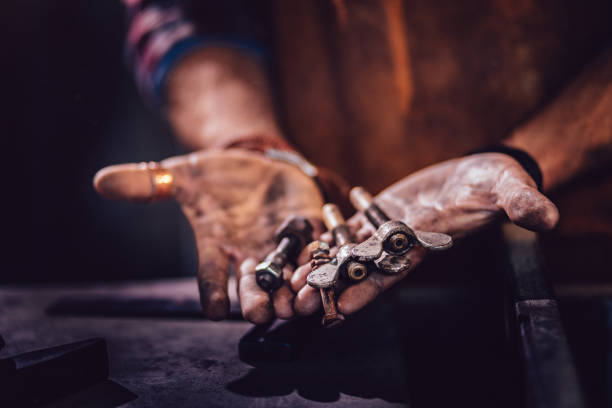 istock Mechanic holding different types of screws in dirty hands 923717114