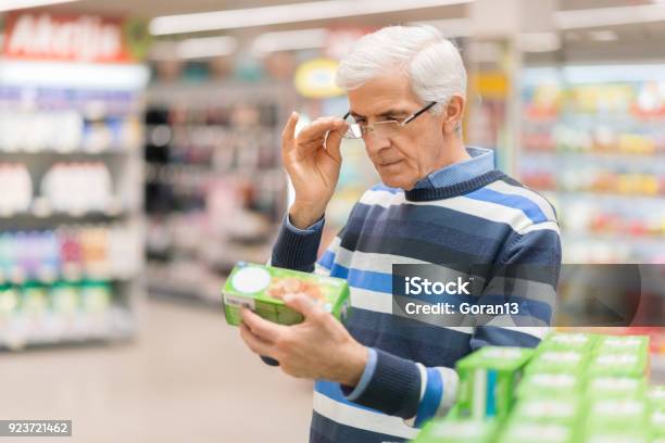 Senior Man Reading Food Label At A Grocery Store Stock Photo - Download Image Now - Nutrition Label, Label, Labeling