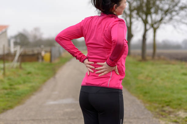 istock Woman with back or kidney pain clutching her back 923728886