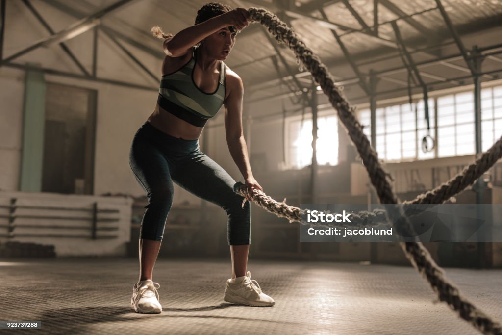 Trabajando con las cuerdas de la batalla en cruz gimnasio atleta - Foto de stock de Entrenar libre de derechos