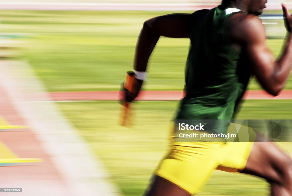 On his way Number 4 runner in the 4x100 relay race. Track Event Stock Photo