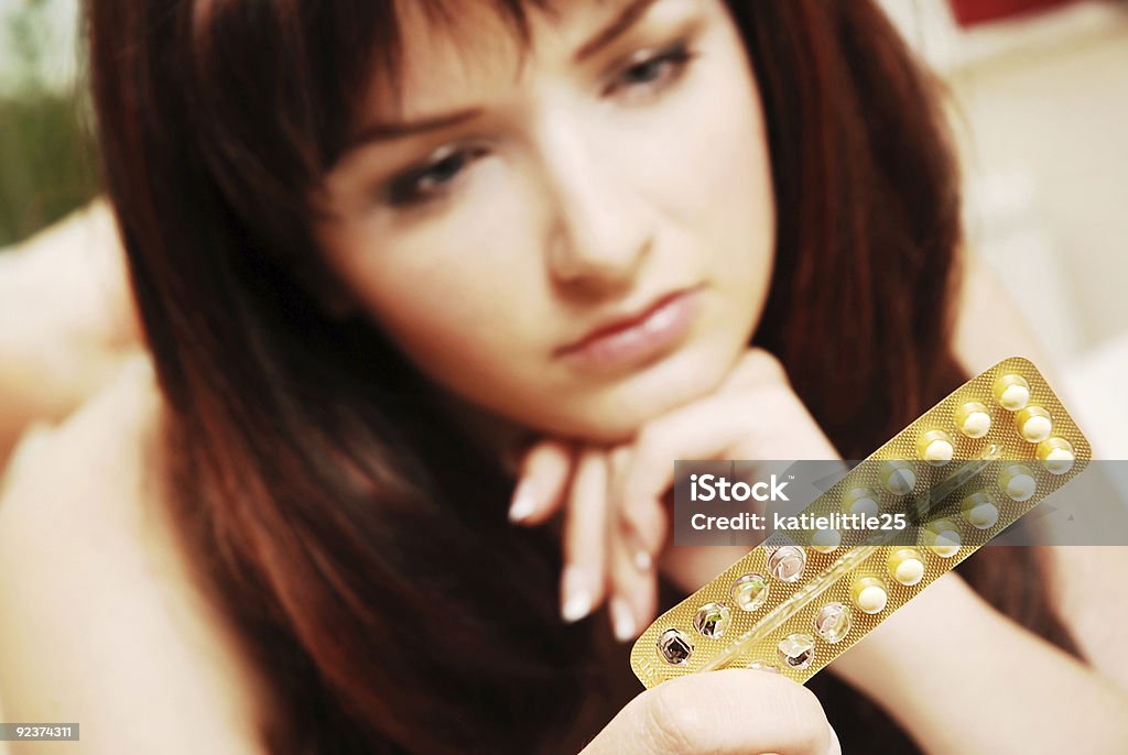 Young woman looking at her contraceptive pills  Birth Control Pill Stock Photo