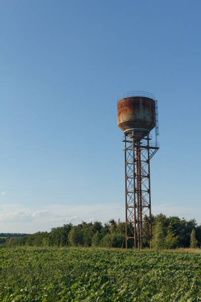 Old small town water tower, sunlight and against a cloudy sky at dusk.