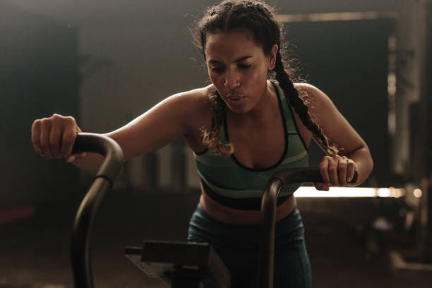istock Woman using exercise bike at the gym 923745216
