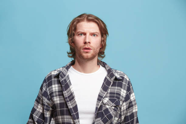 istock Beautiful man looking suprised and bewildered isolated on blue 923748572