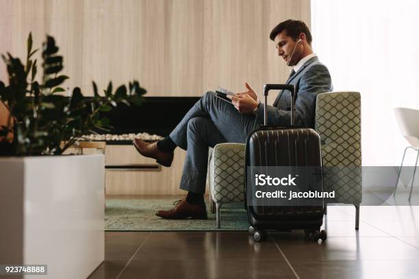 Businessman Reading Magazine In Airport Waiting Room Stock Photo - Download Image Now