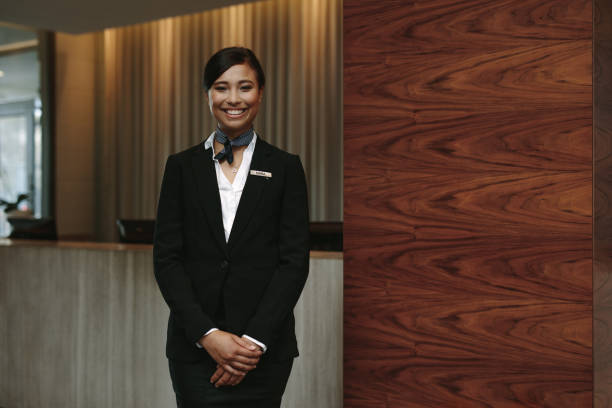 Female receptionist working in hotel Portrait of happy female hotel receptionist standing at workplace. Smiling woman receptionist working in hotel. reception desk photos stock pictures, royalty-free photos & images