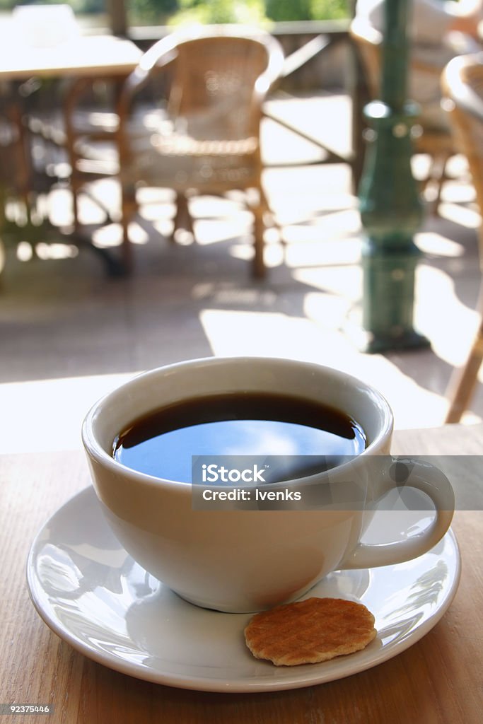 Negro una taza de café con palma y café de la mañana de fondo - Foto de stock de Actividad de fin de semana libre de derechos