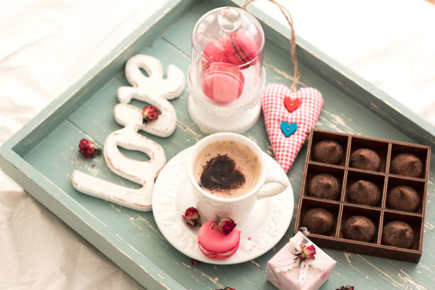 romantic breakfast in bed. Cappuccino ,strawberry macaroons ,gift box on wooden blue table. Valentine's day concept