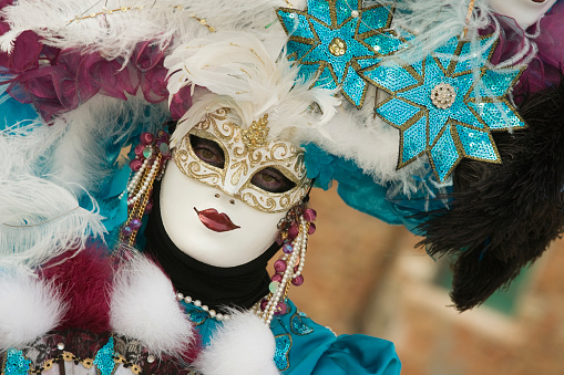 Venice, Veneto, Italy - January 28, 2024: Female Peacock Venetian Carnival Mask Costume Dancing and Posing on St. Mark's Waterfront