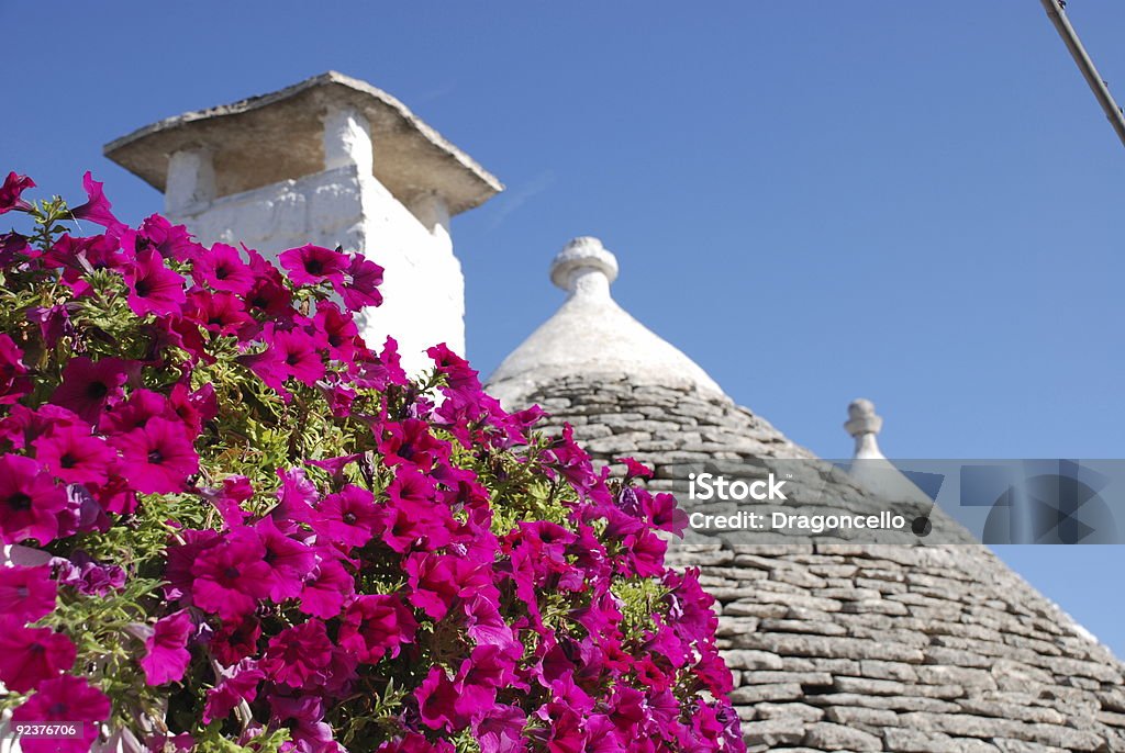 Trullo Roof with Pink Flowers  Alberobello Stock Photo