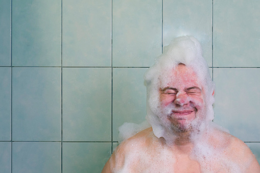 the guy alone in the bathroom washes, the head is all foamy, his eyes were screwed up because of soap